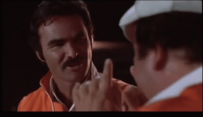 A Man With A Mustache Is Giving The Middle Finger To Another Man GIF