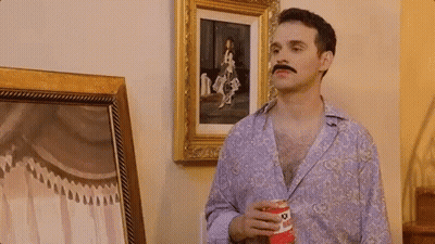 A Man With A Mustache Is Holding A Can Of Pringles GIF
