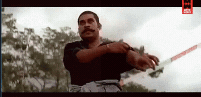 A Man With A Mustache Is Holding A Sword In His Right Hand . GIF