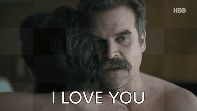 A Man With A Mustache Is Hugging A Woman With The Words I Love You Written Below Him GIF