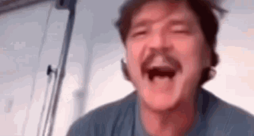 A Man With A Mustache Is Laughing With His Mouth Open In A Blurry Photo . GIF
