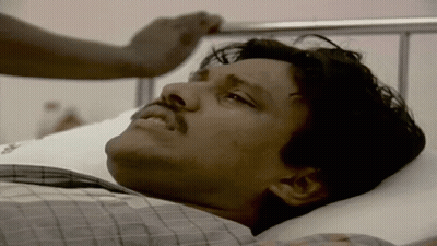 A Man With A Mustache Is Laying On A Hospital Bed GIF