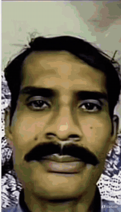 A Man With A Mustache Is Looking At The Camera GIF