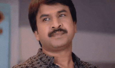 A Man With A Mustache Is Looking At The Camera . GIF
