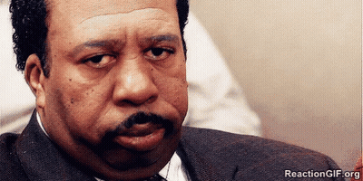A Man With A Mustache Is Looking At The Camera With A Reactiongif.org Watermark GIF