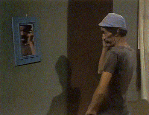A Man With A Mustache Is Looking Out Of A Blue Door GIF