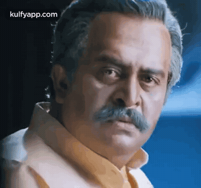 A Man With A Mustache Is Making A Funny Face And Looking At The Camera . GIF