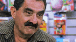 A Man With A Mustache Is Making A Funny Face In A Store GIF