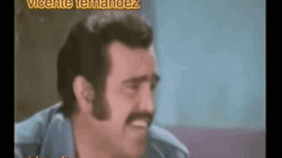 A Man With A Mustache Is Making A Funny Face In A Video . GIF