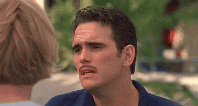 A Man With A Mustache Is Making A Funny Face In Front Of A Woman . GIF