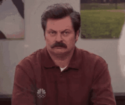 A Man With A Mustache Is Making A Funny Face While Wearing A Red Shirt . GIF