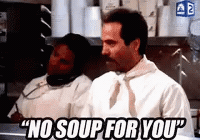 A Man With A Mustache Is Saying `` No Soup For You '' While Standing In A Kitchen Next To A Woman . GIF