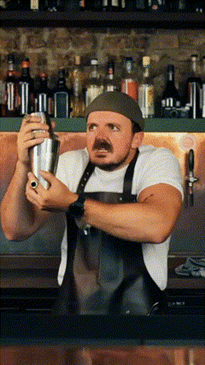 A Man With A Mustache Is Shaking A Drink In A Bar GIF