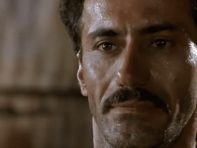 A Man With A Mustache Is Shaving His Face With A Razor GIF