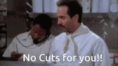 A Man With A Mustache Is Sitting At A Counter Talking On A Phone And Says `` No Cuts For You ! '' GIF