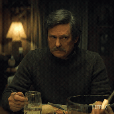 A Man With A Mustache Is Sitting At A Table With A Netflix Logo On The Bottom Right GIF