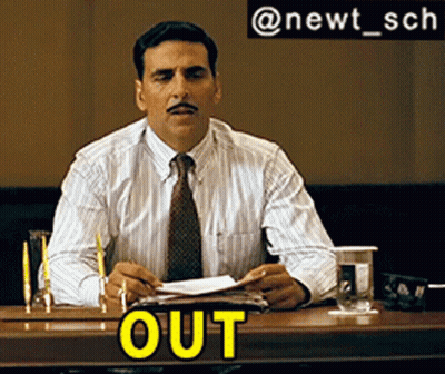 A Man With A Mustache Is Sitting At A Table With The Word Out On The Table GIF