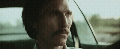 A Man With A Mustache Is Sitting In A Car . GIF