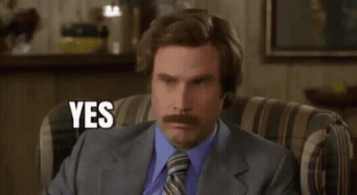 A Man With A Mustache Is Sitting In A Chair And Saying Yes . GIF