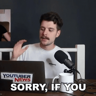A Man With A Mustache Is Sitting In Front Of A Laptop Computer And A Microphone And Says Sorry If You GIF
