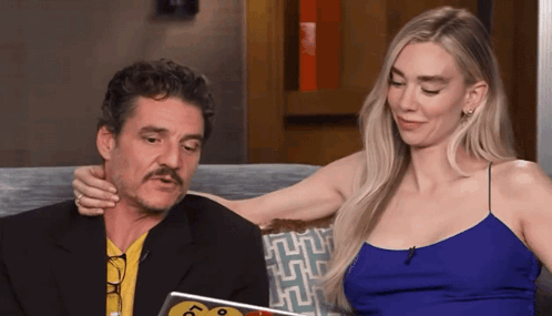 A Man With A Mustache Is Sitting Next To A Woman In A Blue Top GIF