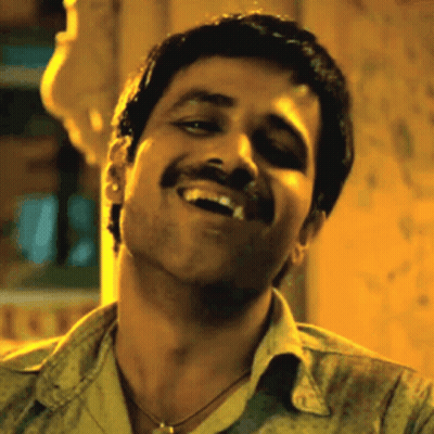 A Man With A Mustache Is Smiling And Making A Face . GIF