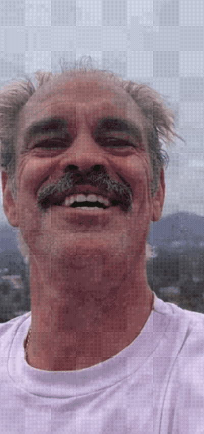A Man With A Mustache Is Smiling And Wearing A Purple Shirt GIF