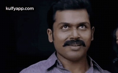 A Man With A Mustache Is Smiling For The Camera . GIF