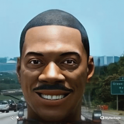 A Man With A Mustache Is Smiling In Front Of A Highway Sign That Says Green Av GIF