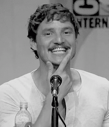 A Man With A Mustache Is Smiling While Talking Into A Microphone GIF