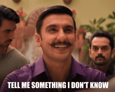 A Man With A Mustache Is Smiling With The Words Tell Me Something I Don 'T Know Below Him GIF
