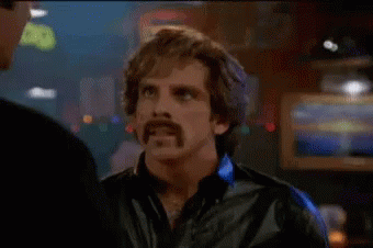A Man With A Mustache Is Smoking A Cigarette And Talking To Another Man In A Bar . GIF