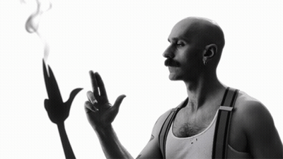 A Man With A Mustache Is Smoking A Cigarette GIF