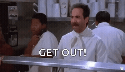 A Man With A Mustache Is Standing In A Kitchen Behind A Counter . GIF