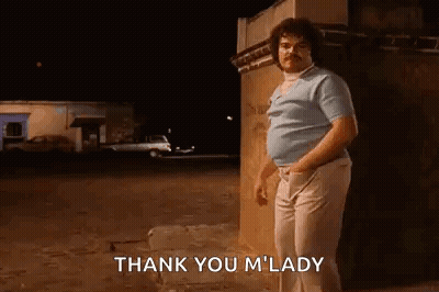 A Man With A Mustache Is Standing In Front Of A Building At Night And Saying `` Thank You M ' Lady '' . GIF