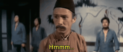 A Man With A Mustache Is Standing In Front Of A Group Of Men And Says Hmm .. GIF
