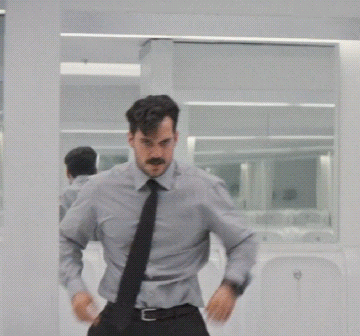 A Man With A Mustache Is Standing In Front Of A Mirror GIF