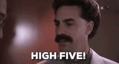 A Man With A Mustache Is Standing In Front Of A Wall And Says `` High Five '' . GIF