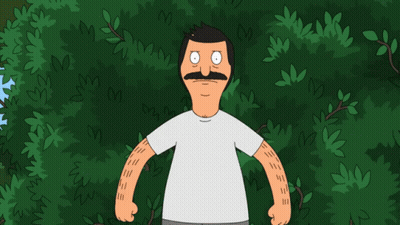 a man with a mustache is standing in front of trees