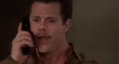 A Man With A Mustache Is Talking On A Cell Phone . GIF
