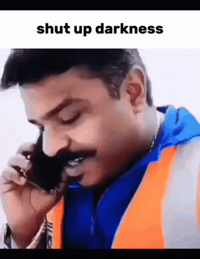 A Man With A Mustache Is Talking On A Cell Phone With The Words Shut Up Darkness Above Him GIF