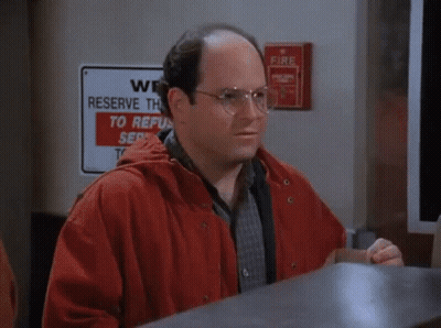 A Man With A Mustache Is Talking On A Phone While Another Man Writes On A Piece Of Paper GIF