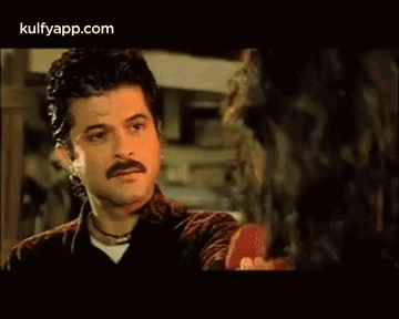 A Man With A Mustache Is Talking To A Woman . GIF