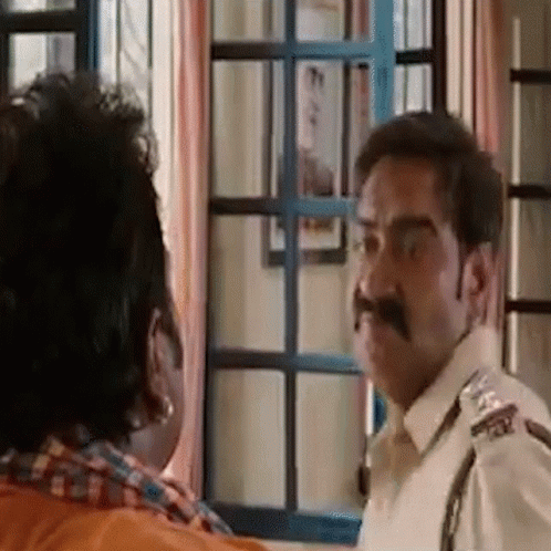 A Man With A Mustache Is Talking To Another Man . GIF
