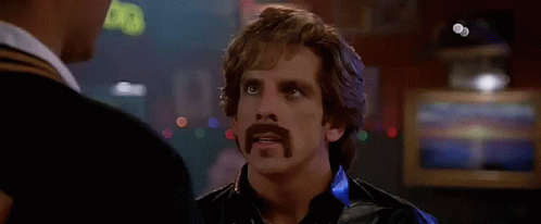 A Man With A Mustache Is Talking To Another Man In Front Of A Sign That Says " Touche " . GIF