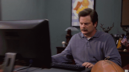 A Man With A Mustache Is Typing On A Keyboard In Front Of A Computer Monitor GIF