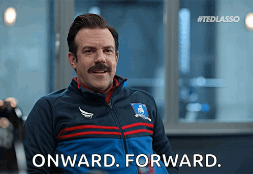 A Man With A Mustache Is Wearing A Blue Jacket That Says Onward Forward GIF