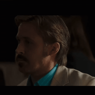 A Man With A Mustache Is Wearing A Blue Shirt And A White Suit GIF