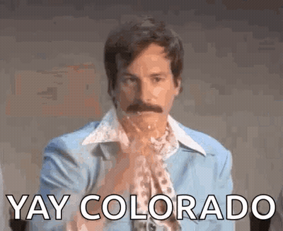 A Man With A Mustache Is Wearing A Blue Suit And A Scarf And Says `` Yay Colorado '' . GIF