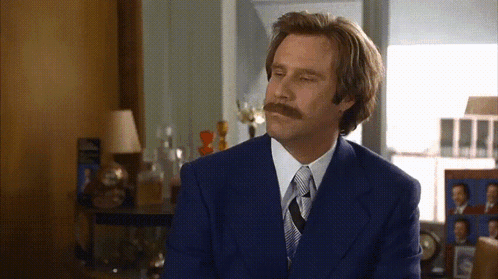 A Man With A Mustache Is Wearing A Blue Suit GIF